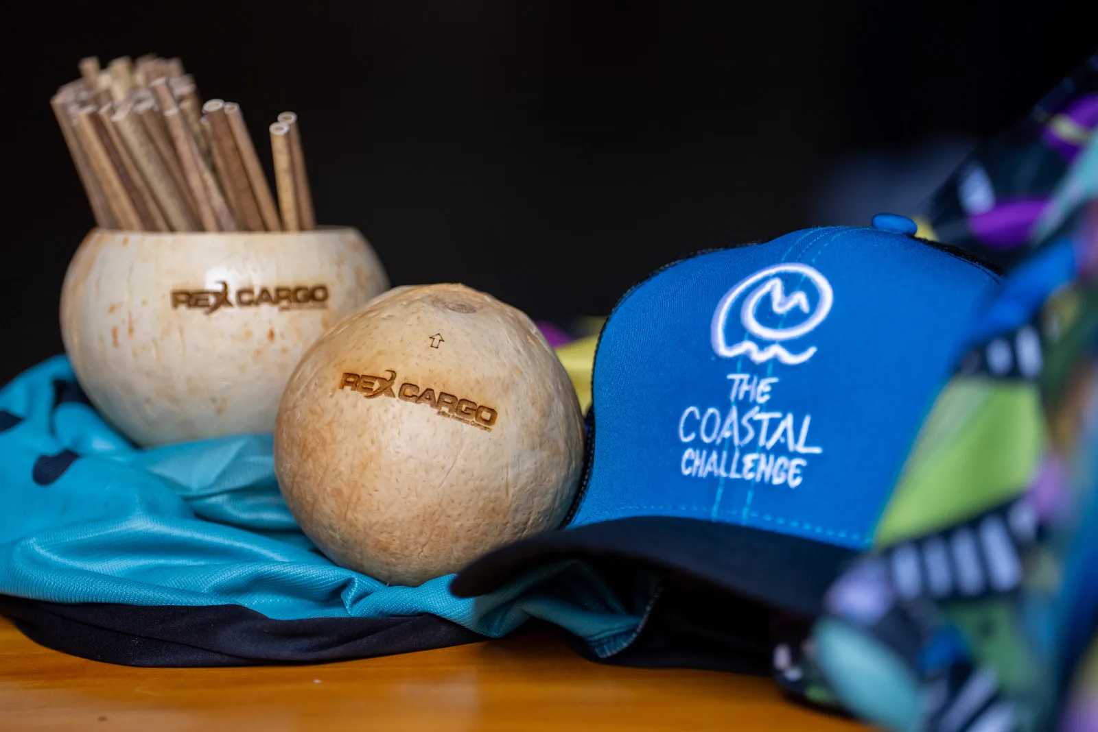 Rex Cargo branded coconuts beside a Coastal Challenge cap